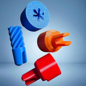 Puede incluir: Un surtido de objetos coloridos impresos en 3D en azul, naranja y rojo. Los objetos incluyen una pieza cilíndrica con un agujero en forma de flor, una columna retorcida y dos piezas con extremos con púas. Los objetos están suspendidos sobre un fondo azul degradado.