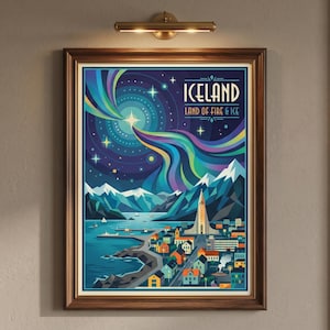 May include: Framed art print of Iceland's landscape, featuring a vibrant depiction of the Northern Lights, mountains, and a coastal town. The artwork includes the text "ICELAND LAND OF FIRE & ICE" in a stylized font, set against a dark blue sky.