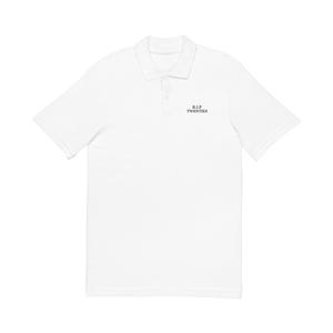 May include: White polo shirt with short sleeves and a collar. The shirt has the text "R.I.P. TWENTIES" in black, positioned on the chest. It has a button-up placket and is made of a smooth fabric.