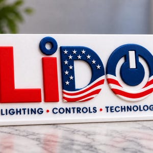 May include: A white rectangular sign featuring the word LIDO in raised letters. The L is red, the i is blue, the D features a blue field with white stars and red and white stripes, and the O is a blue power symbol. Below is LIGHTING • CONTROLS • TECHNOLOGY.