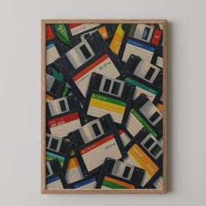 May include: A framed wall art print featuring a collage of vintage 3.5-inch floppy disks in various colors including black, red, green, yellow, and orange. The disks display labels with text such as 1.35 MD, MF-2HD, and A010, arranged in a dense, overlapping pattern.