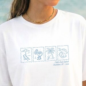 May include: White t-shirt featuring a light blue graphic of four postage stamp designs: a beach chair, a flamingo, a palm tree, and an egg. The text "Cale's Last Splash Charleston, SC - 2024" is below the images.