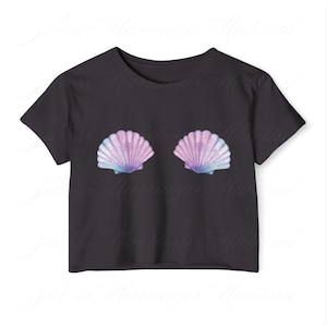 May include: Black crop top with two seashell designs in purple, blue, and white. The shells are placed symmetrically on the front. The top has short sleeves and a round neck.