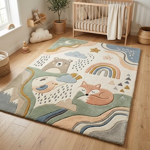 Puede incluir: Una alfombra infantil caprichosa con un diseño de paisaje que presenta un oso, un zorro, un pájaro, un arcoíris y nubes. La alfombra tiene un fondo crema con acentos verdes, azules y beige. Mide aproximadamente 152 cm x 203 cm.