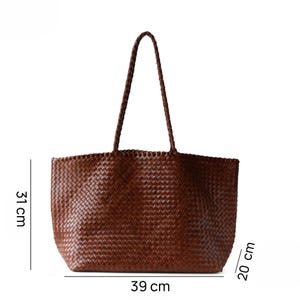 May include: A brown woven tote bag with a braided handle. The bag is 15.3 inches wide, 12.2 inches tall, and 7.9 inches deep. The bag has a rectangular shape and is made of a woven material.