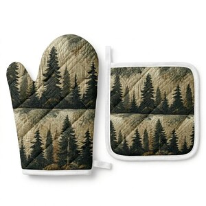 Puede incluir: Juego de manopla y agarradera acolchadas con un diseño de bosque. La manopla y la agarradera presentan árboles de color verde oscuro sobre un fondo marrón claro, con ribete blanco y un patrón acolchado. La agarradera es cuadrada y la manopla es de tamaño estándar.