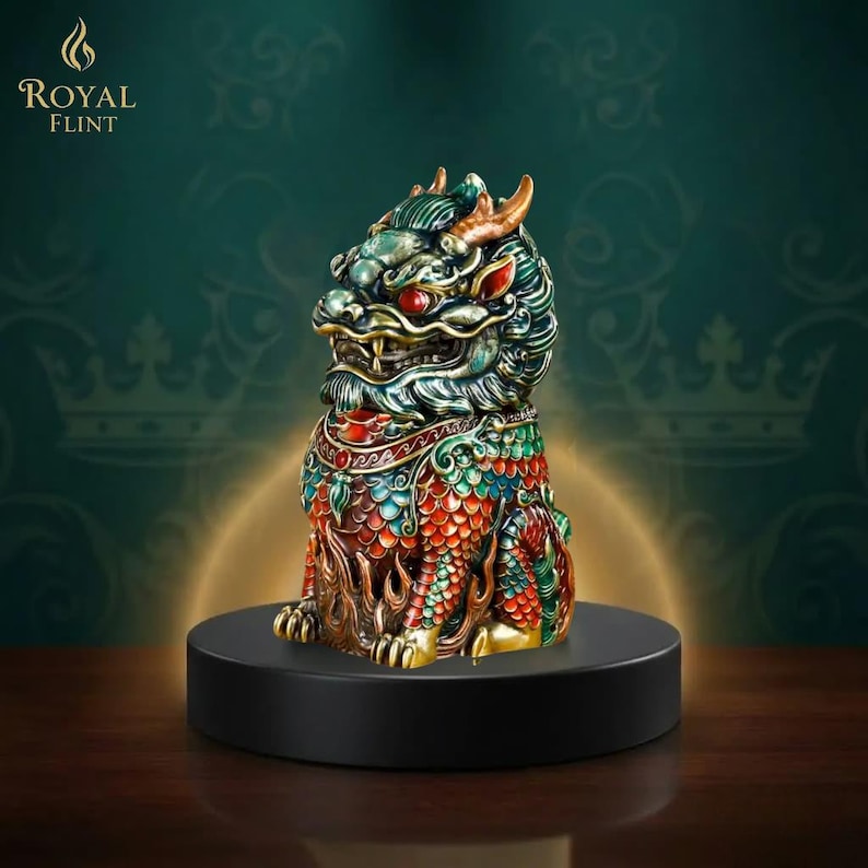 Puede incluir: Una detallada y colorida figura de una criatura m&iacute;tica, posiblemente un drag&oacute;n o un le&oacute;n, con ojos rojos, cuernos dorados y patrones intrincados en verde, rojo y dorado. La figura est&aacute; sobre una base circular negra, con el logo "Royal Flint".