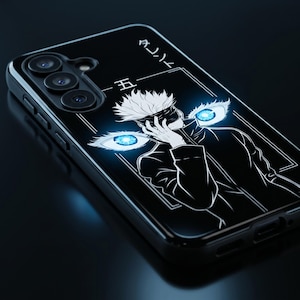 Puede incluir: Funda de teléfono negra con una ilustración de anime en blanco y negro. El diseño incluye un personaje con cabello blanco, una venda en los ojos y ojos azules brillantes. También hay texto japonés.