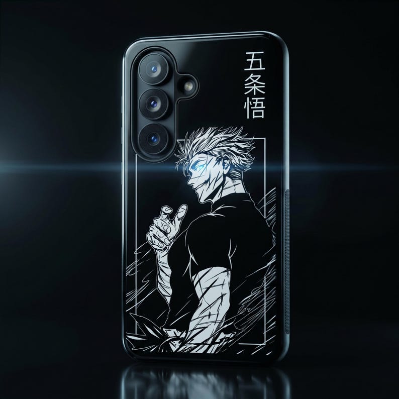 K&ouml;nnte beinhalten: Eine schwarze Smartphone-H&uuml;lle mit einer wei&szlig;en Strichzeichnung eines Anime-Charakters mit stacheligen Haaren. Das Design enth&auml;lt den japanischen Text 五条悟 in vertikaler Ausrichtung. Die H&uuml;lle hat einen Ausschnitt f&uuml;r eine Dreifachkamera.