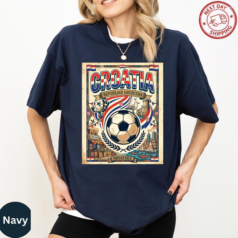 A woman wearing a navy blue t-shirt with a graphic design featuring a soccer ball, a flag, and text related to Croatia.