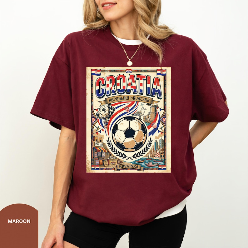 A woman wearing a burgundy t-shirt with a graphic design featuring a soccer ball, a flag, and various elements associated with Croatia.