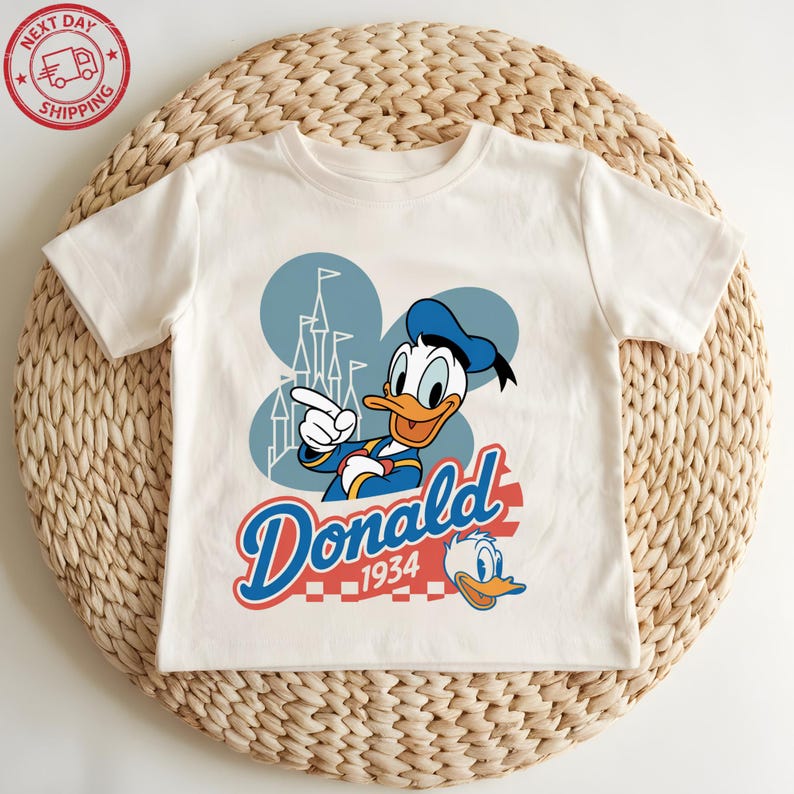 A white t-shirt with a cartoon image of a duck and the text "Donald" and "1934" printed on it.