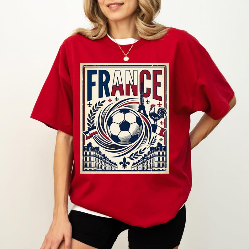 A woman wearing a red t-shirt with a graphic design featuring a soccer ball, buildings, and a rooster, along with the word "FRANCE" prominently displayed.