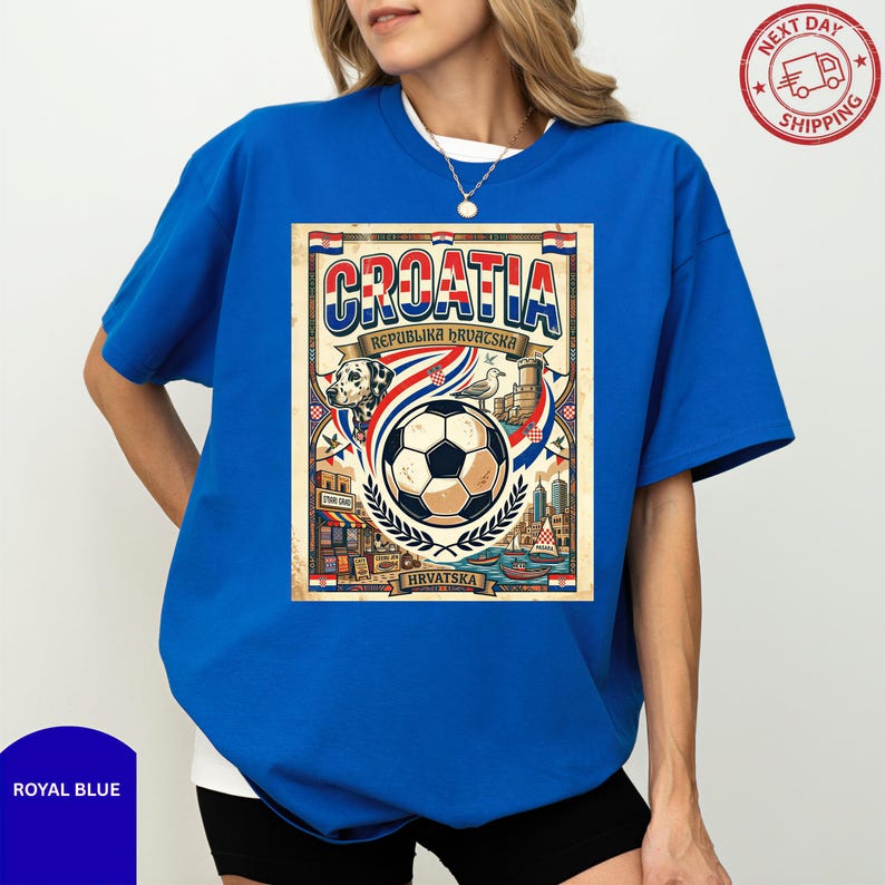 A woman wearing a blue t-shirt with a graphic design featuring a soccer ball and various elements associated with Croatia.