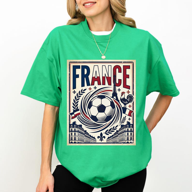 A woman wearing a green t-shirt with a graphic design featuring a soccer ball, buildings, and a rooster, along with the word "FRANCE" prominently displayed.