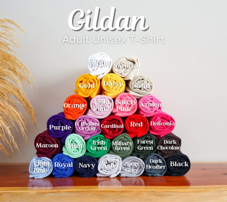A pyramid-shaped arrangement of colorful rolled-up shirts, each with a different color, displayed on a wooden surface.