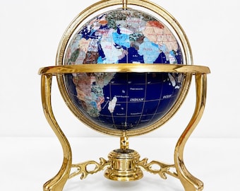 Globo terráqueo antiguo con incrustaciones de piedras semipreciosas y soporte de latón para escritorio.