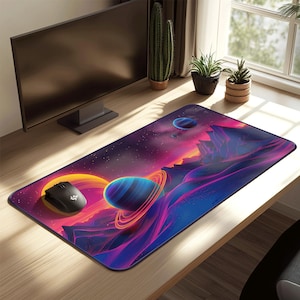 May include: A rectangular mouse pad featuring a vibrant space-themed design. The pad showcases planets with rings, mountains, and a colorful nebula in shades of purple, blue, orange, and yellow. A black computer mouse is on the left.