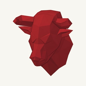 Può includere: Una scultura a testa di toro rosso scuro caratterizzata da un design geometrico low-poly con sfaccettature angolari nette. L'oggetto da parete mostra una struttura stilizzata e sfaccettata che forma la sagoma di un toro con corna e orecchie.