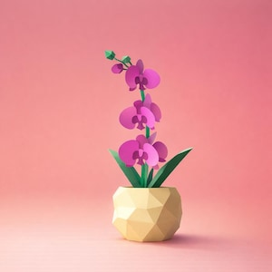 以下が含まれることがあります： ピンク色の背景に、幾何学的な黄色の鉢に入ったペーパークラフトの蘭。 蘭は鮮やかなマゼンタ色の花、緑の葉、緑の茎が特徴です。 鉢は多面的なデザインです。