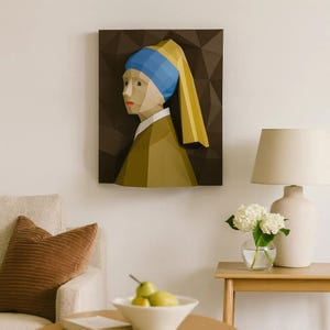 May include: A geometric wall art piece depicting a woman with a blue head covering and a yellow scarf, reminiscent of Vermeer's "Girl with a Pearl Earring." The artwork features a brown background and is mounted on a wall, adding a touch of classic art to the room.