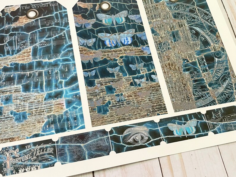 May include: Three vintage style gift tags with a blue and silver cracked paint design. The tags feature a variety of images including a crystal ball, a celestial map, and a moth. The text on the tags reads "The Crystal Ball" and "The Fortune Teller".