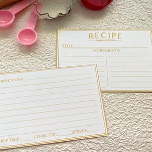 May include: Two blank recipe cards with gold trim and lines. The top card has the title "RECIPE made with love" and the heading "INGREDIENTS". The bottom card has the headings "DIRECTIONS", "PREP TIME", "COOK TIME", and "SERVES".