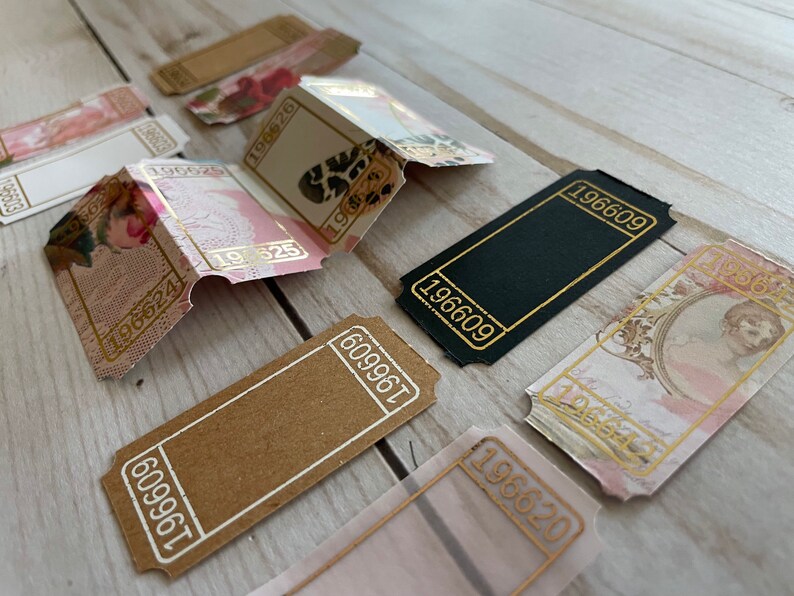 May include: A collection of vintage-style ticket stubs with gold accents and various designs, including floral patterns, a black and white animal print, and a portrait of a woman. The numbers 196609, 196620, 196624, 196625, 609961, and 196628 are visible on the tickets.