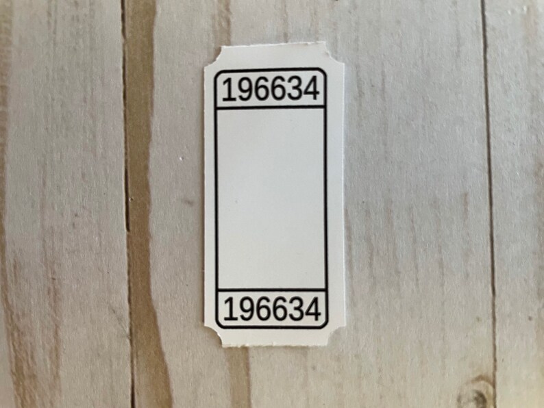 May include: White ticket with black borders and the number 196634 printed at the top and bottom.