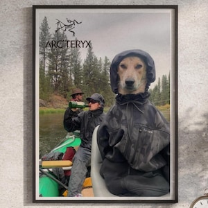 Puede incluir: Un póster de pared enmarcado que muestra a un perro con una chaqueta con capucha gris oscuro con el logotipo y el texto de Arc'teryx en la parte superior. El fondo muestra a dos personas en una balsa verde en un río rodeado de pinos.