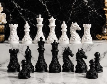 May include: A complete chess set with black and white pieces. The white pieces include rooks, bishops, a queen, and a king. The black pieces include rooks, bishops, a queen, and a king. The chess pieces are arranged on a marble surface.