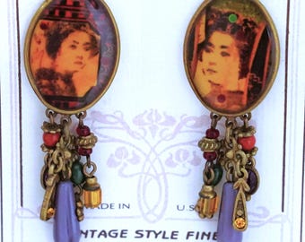 May include: Vintage-style earrings with oval-shaped pendants featuring a portrait of a woman. The earrings have dangling charms in shades of gold, red, green, and purple. The text "Sweet Romance" and "Vintage Style Fine" are visible on the card.