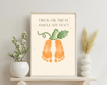 May include: A rectangular wall art print on a cream background featuring the black text TRICK OR TREAT, SMELL MY FEET above a watercolor illustration of two orange baby footprints shaped like a pumpkin with a green stem and leaves.