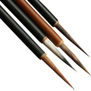 May include: A set of four calligraphy brushes with long, slender handles. Two brushes feature matte black handles, while the other two have natural brown wooden handles. Each brush has a pointed tip with fine, soft bristles in varying shades.