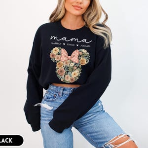 May include: Black sweatshirt with the word "mama" in white script. Below the word "mama" are the names "Nathan", "Chole", and "Jordan". The sweatshirt features a floral Minnie Mouse head design with a pink bow.