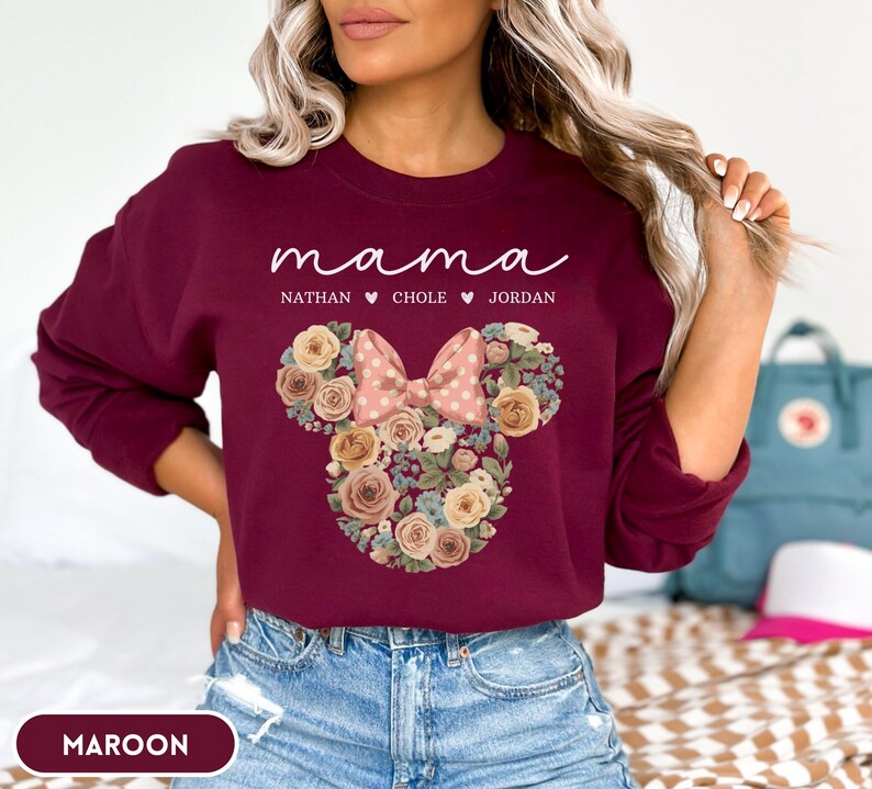 May include: Maroon sweatshirt with the word "mama" in white script, and the names Nathan, Chole, and Jordan below. A floral Minnie Mouse design is in the center, with a pink polka dot bow.