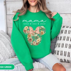 May include: Irish green sweatshirt with the word "mama" in white script. Below the word "mama" are the names Nathan, Chole, and Jordan. A floral Mickey Mouse head design with a pink bow is in the center.