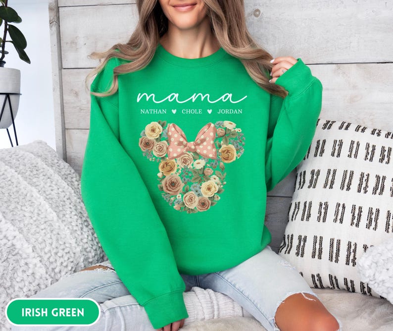 May include: Irish green sweatshirt with the word "mama" in white script. Below the word "mama" are the names Nathan, Chole, and Jordan. A floral Mickey Mouse head design with a pink bow is in the center.