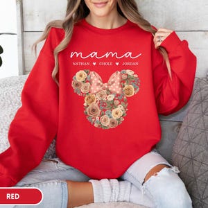 May include: A red sweatshirt with the word "mama" in white script. Below the word "mama" are the names Nathan, Chole, and Jordan. A floral Minnie Mouse design is in the center of the sweatshirt.