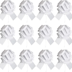 Puede incluir: Doce lazos blancos para tirar, cada uno con una larga cola rectangular. Los lazos están hechos de un material brillante similar a una cinta y están dispuestos en una cuadrícula. Ideales para envolver regalos o decoraciones de fiestas.