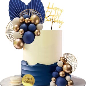 Può includere: Torta di compleanno a due piani blu navy e crema. Decorata con sfere dorate e blu navy, dettagli dorati e un cake topper dorato "Happy Birthday". Un adesivo dorato con "Happy Birthday" è sulla base.