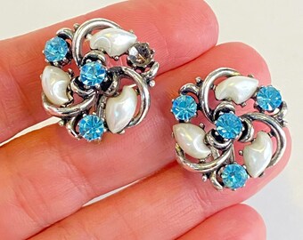 Orecchini vintage Lisner con chiusura a vite, strass blu, dentini da latte e perle finte. LEGGI