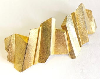 Hebilla de cinturón brutalista vintage, tono dorado, textura geométrica, firmada por Lauren J.