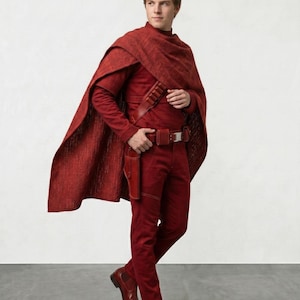 May include: A person in a red costume with a cape, long-sleeve shirt, pants, and boots. The costume includes a belt with a holster. The outfit is a solid, deep red color.