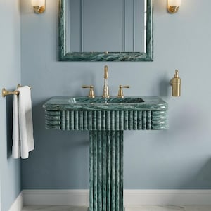 May include: A luxurious bathroom scene featuring a green marble sink, mirror, and pedestal. The sink has gold fixtures and is paired with a fluffy green bath mat. Two sconces flank the mirror, and a white towel hangs on a gold towel rack.
