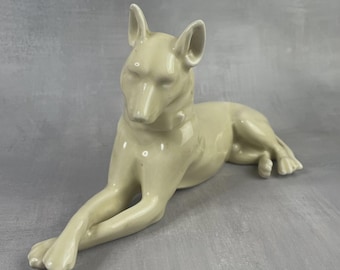 Figura de porcelana color crema beige de un pastor alemán, perro tumbado con las patas cruzadas, figura decorativa vintage de 23 cm.