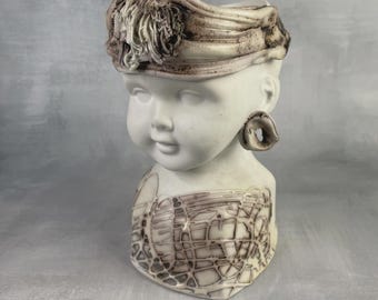 Maceta vintage de porcelana bizcochada Philippe Léger con cabeza en forma de busto, que recuerda a la cabeza de un niño o un bebé; una pieza decorativa para la habitación de un niño.