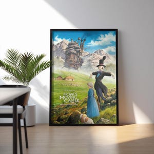 Puede incluir: P&oacute;ster enmarcado de la pel&iacute;cula de animaci&oacute;n "El castillo ambulante". La obra de arte representa un castillo caprichoso, personajes en un campo y el t&iacute;tulo de la pel&iacute;cula. El p&oacute;ster est&aacute; en un marco negro y se apoya en una pared blanca.