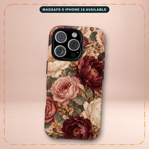 May include: A smartphone case featuring a floral pattern with deep burgundy, dusty pink, and cream-colored roses and green leaves. The case has a black camera cutout and a label at the top stating MAGSAFE & IPHONE 18 AVAILABLE.