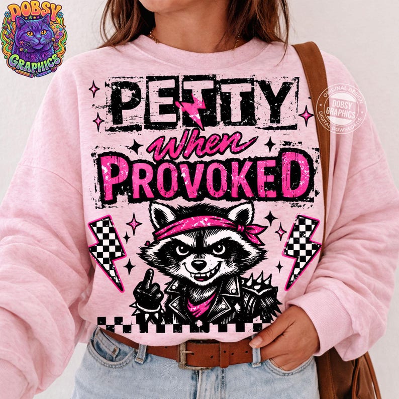 May include: Pink sweatshirt with the text "PETTY when PROVOKED" and a graphic of a raccoon wearing a bandana and leather jacket. The raccoon is giving the middle finger. The design includes lightning bolts and stars.